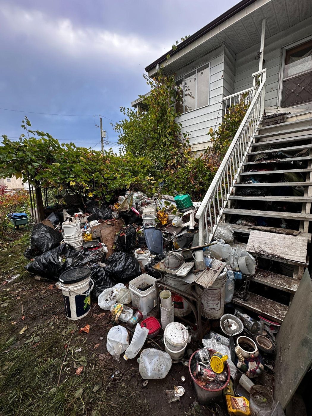 Before: bags, bottles and junk piled beside a house's back stairs