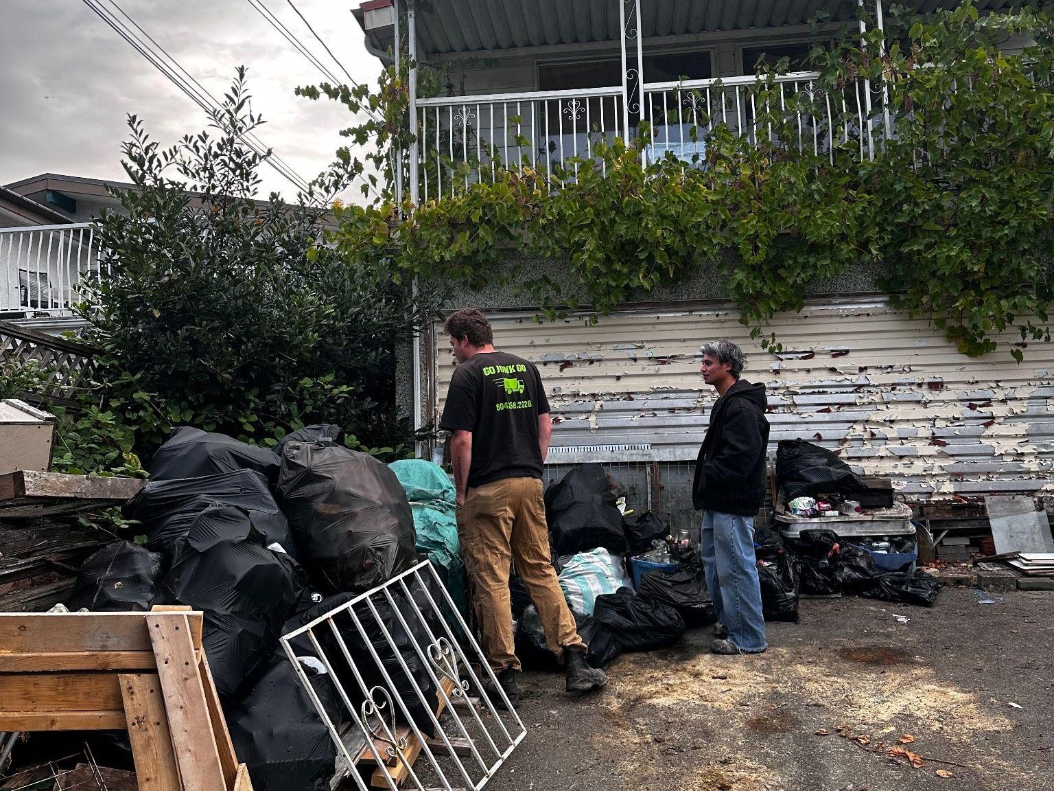 Go Junk Go crew loading bagged recyclables and junk from a backyard cleanout